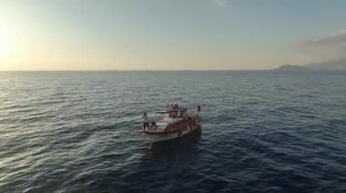 Kıyı şeridi boyunca gün batımı balık tutma sahnesi.