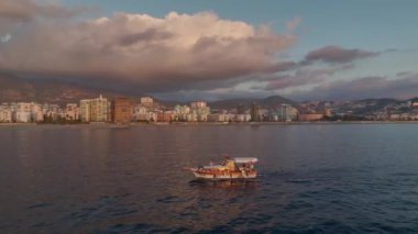 Bir balıkçı huzurlu bir günbatımı manzarasının tadını çıkarır..