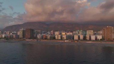 Şehir ve denizin üzerinde nefes kesici bir gün batımı.