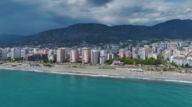 Yumuşak bulutlu gökyüzünün altında sakin bir sahil.