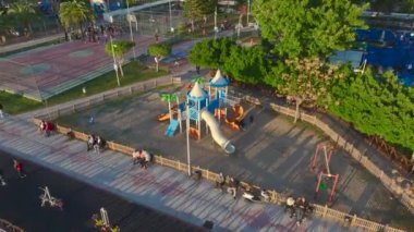 Çocuklar güneşli bir parkta eğleniyor..