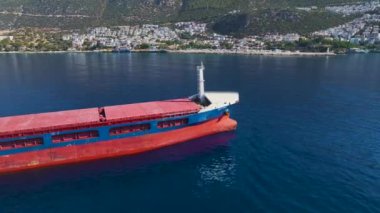 Kargo gemisinin okyanusun ortasına demir atarken derin mavi sulara yerleşmesini izleyin..