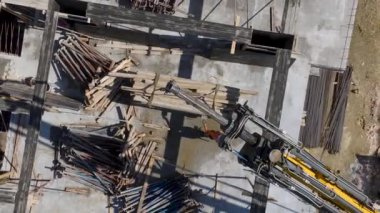 İşçilerin zemini beton dökmeye hazırladıkları yoğun inşaat alanına bakın..