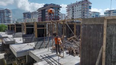 Yoğun bir inşaat sahasına beton dökülmesi için zemini hazırlayan işçilere bakın.