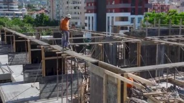 İnşaat işçilerinin inşaat alanını bir sonraki beton döküm için hazırlamalarını izleyin..