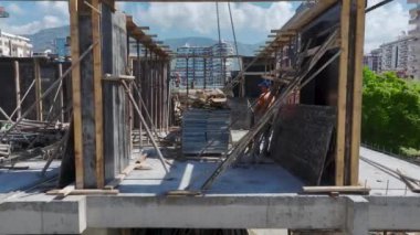 İşçilerin yeni bir binaya beton dökülmesi için zemini hazırlamalarını izleyin..