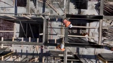 İnşaat işçilerinin yoğun bir inşaat sahasına beton dökülmesi için zemini hazırlamalarına bakın..