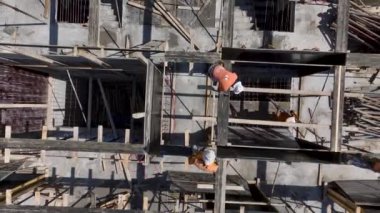 İnşaat işçilerinin yoğun bir inşaat sahasına beton dökülmesi için zemini hazırlamalarına bakın..