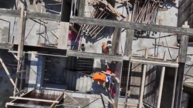 İnşaat işçilerinin yoğun bir inşaat sahasına beton dökülmesi için zemini hazırladıklarını görün..