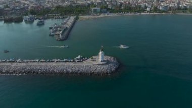 Limandaki ikonik Alanya deniz fenerini izleyin, durgun, kristal berrak denizin yanında.