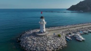 Alanya Limanı 'nda dimdik duran güzel deniz fenerine bakın. Etrafı açık mavi denizlerle çevrili..
