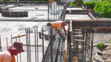 Çalışanlar inşaat demirini büküyor ve inşaatın geleceği için zemin hazırlıyorlar..