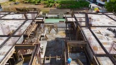 İnşaat işçileri demirleri bükerken ve zemini gelecek iş için hazırlarken izleyin..