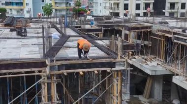 İnşaatçılar inşaat çalışmalarının gelecek aşamaları için zemini hazırlıyor ve demiri büküyorlar..