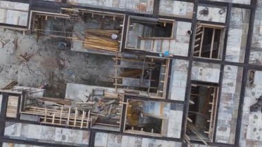 İnşaatçılar inşaat projesinde zemini hazırlıyor ve demiri büküyorlar..