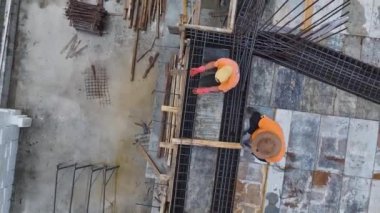 İşçiler inşaat projesinin bir sonraki aşaması için demirleri bükmekle ve zemini hazırlamakla meşguller..