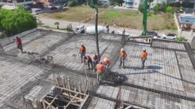 İnşaat alanında ileriki adımlar için inşaat demirleri ve zemin hazırlayan işçileri izleyin..