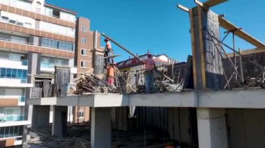 İşçilerle dolu hareketli bir inşaat sahası uzmanlıkları ve takım çalışmaları ile ilerleme kaydediyor..