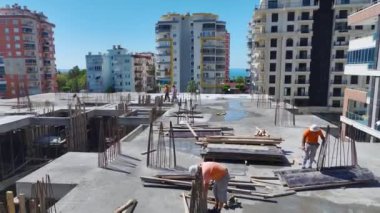 İşçilerin işlerle ustalıkla ilgilendiği ve sürekli ilerleme kaydettiği hareketli bir inşaat sahası.