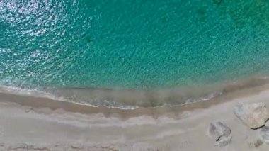 Bir grup, güneşin altında dinlenerek kristal berraklığında yüzmeyi ve kürek çekmeyi seviyor..