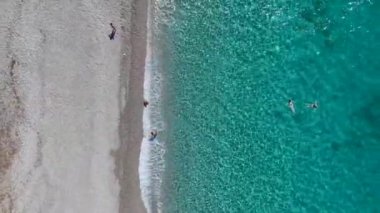 Bir grup, temiz sularla dolu sihirli bir sahilde kürek çekmeyi ve yüzmeyi seviyor..