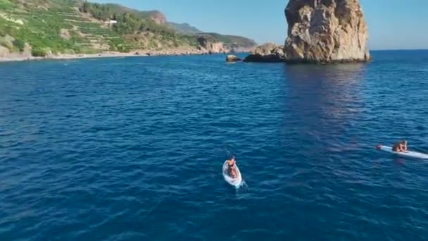 Un groupe apprécie la plage magique, la natation, les bains de soleil et le paddleboard dans des eaux cristallines.