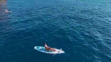 İnsanların yüzdüğü, güneşlendiği ve sörf yaparken eğlendiği berrak suları olan çarpıcı bir sahil..