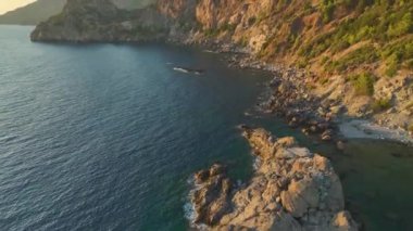 İnsanlar kristal berrak suyla yüzerek, dinlenerek ve kürek çekerek sihirli bir günün tadını çıkarırlar..