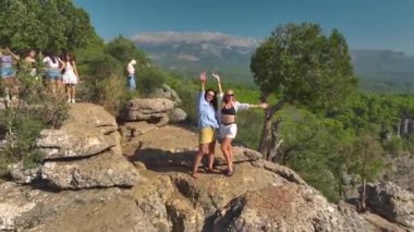 İki arkadaş nefes kesici bir kanyonun kenarında poz verir manzaranın tadını çıkarır ve güzel anları yakalar..