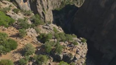 Türkiye 'de bir kanyonun kayalıklarında poz veren iki kız, büyüleyici manzaranın tadını çıkarıyor.