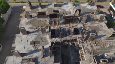 Vinçler ve işçilerin gözle görülür ilerleme kaydettiği yüksek katlı bir bina inşa ediliyor.