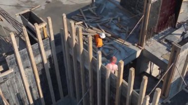 İşçilerin ve vinçlerin çok katlı bir bina inşa ettiği hareketli bir inşaat alanı..