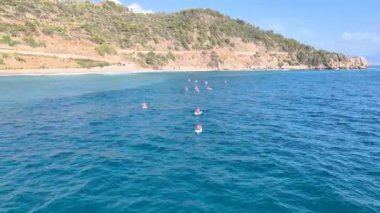 Açık denizde kürek çeken bir grup vahşi bir sahilde rahat bir kamp kuruyor..