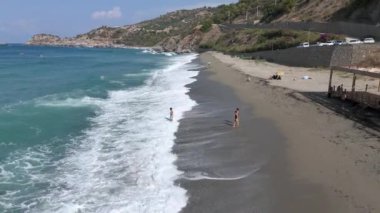 Açık denizde kürek çeken bir grup gece için kampa hazırlanmak üzere vahşi bir sahile varır..