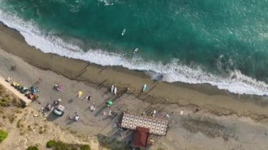 Bikini modelini izleyin. Beyaz bir kumsalda dinleniyor. Çarpıcı turkuaz suyla..