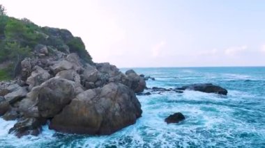 Fırtınalı deniz şafak vakti kayalık kıyıya vurur ve okyanusun güzel dokusunu gösterir..