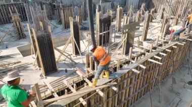 İşçilerin ve vinçlerin yeni bir proje inşa ettiği yoğun bir inşaat alanı.