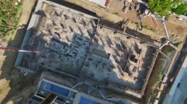 İşçilerin ve vinçlerin yeni bir proje inşa ettiği yoğun bir inşaat alanı.