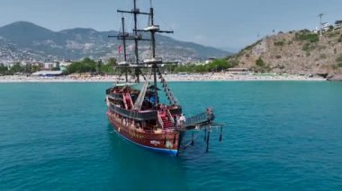 İnsanların çeşitli su sporları ve eğlenceli aktivitelerden zevk aldığı temiz, beyaz bir Akdeniz sahili..