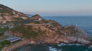 Gün batımı ışığı kayalık sahili kaplıyor, Akdeniz 'in üzerinde çarpıcı bir manzara yaratıyor..