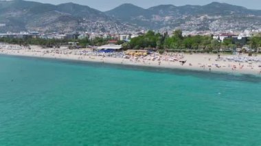 Akdeniz 'de su sporları ve aktivitelerle dolu berrak sularla dolu güzel beyaz bir sahil..