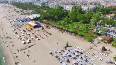 İnsanların su oyunları oynadığı ve Akdeniz 'de eğlendiği canlı beyaz bir sahil..