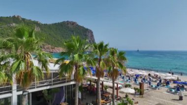 Akdeniz 'de insanların su sporlarını ve eğlenceli aktiviteleri sevdiği parlak beyaz bir plaj..