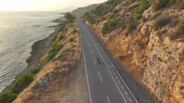 Heyecan verici bir motosiklet yarışı Akdeniz kıyısında hızla ilerliyor, manzaralı okyanus manzaralı..