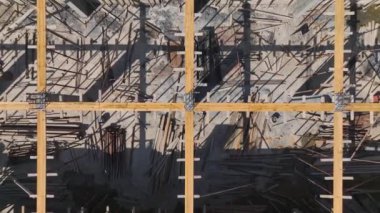 İşçiler ve ağır makinelerle dolu yoğun bir inşaat alanı aktif olarak yeni bir yapı inşa ediyor..