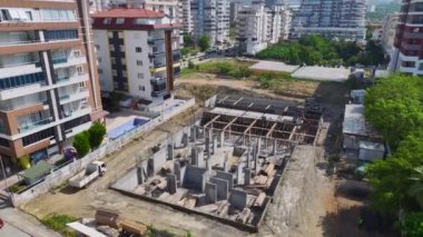 İşçiler ve makineler aktif olarak bir inşaat projesi üzerinde çalışıyor, adım adım yeni yapılar inşa ediyorlar..