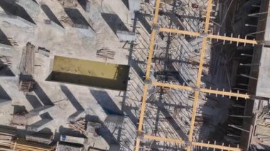 Yeni bir binanın temelini etkin bir şekilde şekillendiren yoğun işçilerin ve ağır makinelerin bulunduğu bir inşaat alanı..