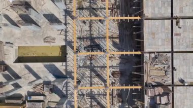 Ağır makineler ve işçiler inşaat alanında çok çalışıyor, malzeme taşıyor ve inşaat yapıları inşa ediyorlar.
