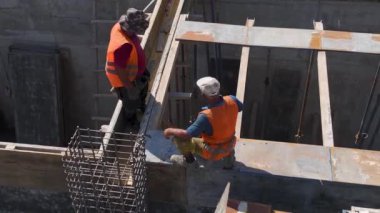 İşçiler ve makineler yoğun bir inşaat alanında aktif olarak yeni bir yapı inşa ediyor ve geliştiriyor.