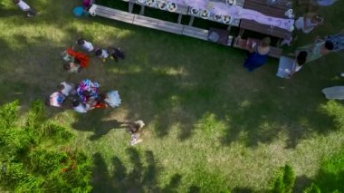 Arkadaşların yemekten, kahkahadan ve doğanın güzelliğinden zevk aldığı yemyeşil bir bahçede şenlikli bir piknik..